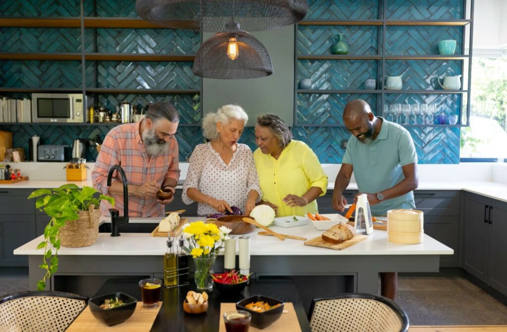 Two couples work together preparing ingredients for a healthy meal in assisted living